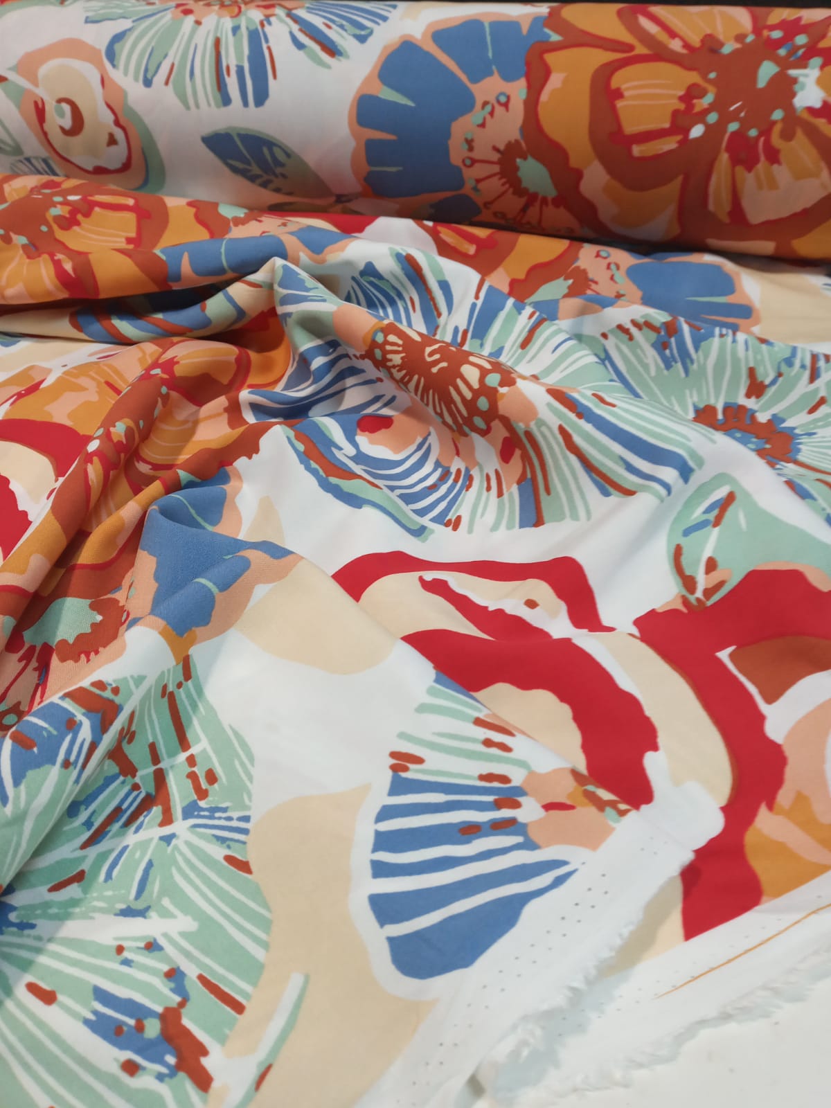 imagen de Fibrana estampada fondo blanco con diseños en azul, naranja y rojo